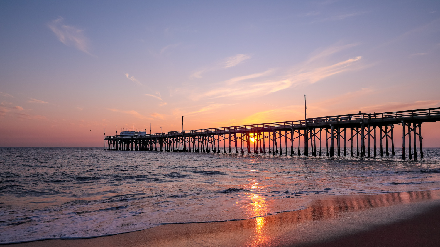 A setting sun behind the long pier, Irvine, Orange County, California