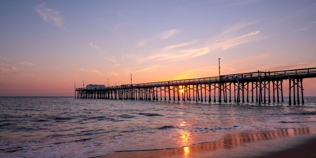 A setting sun behind the long pier, Irvine, Orange County, California